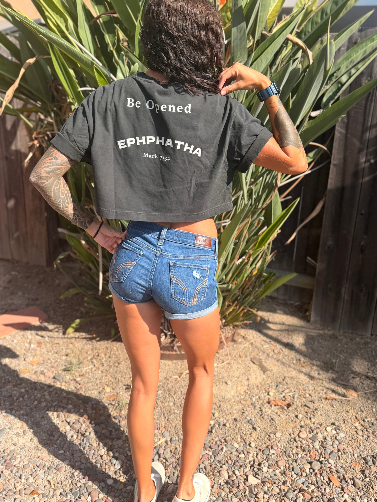 Back of black Ephphatha crop tee with Be Opened Mark 7:34 design